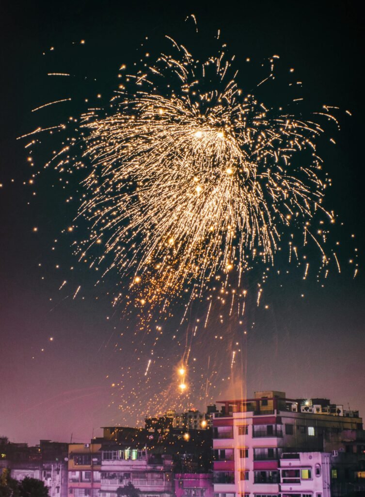 A vibrant fireworks display illuminates the city skyline, celebrating a festive occasion at night.